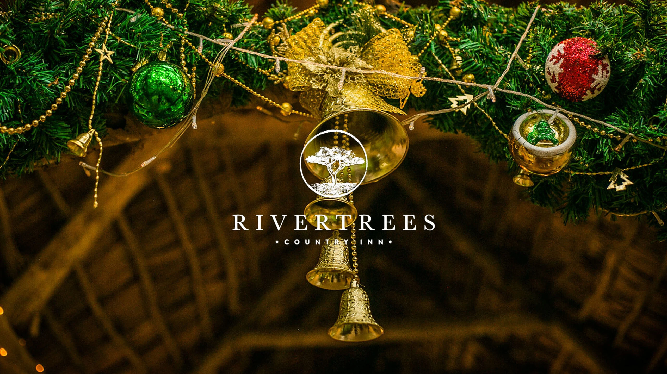 Rivertrees Country Inn logo over a festive garland of gold bells and baubles under thatch