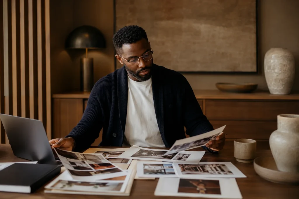 Creative director reviewing printed brand materials and moodboards at a desk